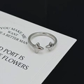 Detail eines silbernen Sternenrings mit verstellbarem Band auf einer Displaykarte - 3D Vierpunktstern-Anhänger-Stil (JZ1312)