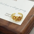Makroaufnahme goldener Blumenring mit gebürsteten Blüten und Zirkonia-Details - Doppelblumen-Gebürstete Textur (JZ0133A)