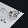 Nahaufnahme eines Star-Punk-Rings mit rotem Zirkon und Perle auf einer minimalistischen Karte - Rubin-Perlen-Stern-Stil (JZ1732)