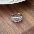 Detailed macro view of an open silver ring with a purple zircon stone on a wooden surface - Gorgeous Retro Round Hollow Drill Style(JZ5269)