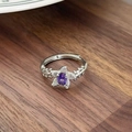 Macro shot of silver ring with oval purple gemstone and floral zircon petal details - Oval Purple Gemstone Petal Decor Style(JZ5469)