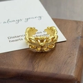 Gros plan d'une bague croix dorée ajourée avec zircons de style baroque vintage - Style Creux Floral Croix Baroque (JZ3999)
