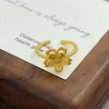 Vue détaillée d'une bague fleur vintage dorée avec anneau torsadé sur socle en bois - Style Floral Florissant à Texture de Corde Torsadée (JZ4620A)