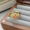 Dettaglio anello vintage dorato con fiore di zircone rosa su velluto grigio - Aperto Regolabile / Stile Fiore a Quattro Petali in Rilievo Cavo (JZ3238A)