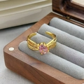 Dettaglio di un anello con gemma rosa ovale e fasce dorate multistrato con piccoli diamanti - Aperto Regolabile / Stile Ovale a Tre Strati Sovrapposti (JZ4106)