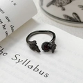 Gros plan d'une bague papillon gothique avec pierre rouge sur une page de livre ancien - Ouvert Réglable / Style Papillon Et Look Rubis (JZ2118A)