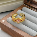 Dettaglio di anello vintage dorato con intagli traforati e una gemma rosa ovale incastonata - Aperto Regolabile / Stile Ovale Intagliato Cavo (JZ5663)