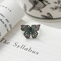 Détail de la bague papillon émaillée vintage sur page de livre au style punk gothique - Ouvert Réglable / Style Papillon Émail Sarcelle (JZ2662A)
