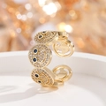 Makroaufnahme von vergoldetem Smiley-Ring mit Zirkonia-Pavé und blauen Edelstein-Augen - Gold Saphirblau Zirkonia Ring