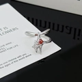 Detalle macro del anillo de estrella plateada con centro de rubí rojo y circonitas blancas - Estilo Piedra Principal Color Rubí Doble Estrella (JZ1731)