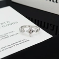 Detalle macro de anillo plateado ajustable con circonitas brillantes sobre tarjeta blanca - Estilo Estrella del Norte Centro Circón (JZ2420)