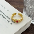 Dettaglio dell'anello vintage dorato con zircone rosso e motivi traforati eleganti - Aperto Regolabile / Stile Traforato Tondo Oro Rosso (JZ1704A)