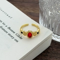 Dettaglio anello vintage dorato con pietra rossa e motivi goffrati su un libro - Aperto Regolabile / Stile Pietra Preziosa in Rilievo Retro Rosso Nero (JZ4216)
