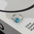 Macro shot of adjustable silver ring with blue zircon stone and side diamond accents - Blue Round Style (JZ5154A)