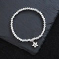 Poliertes Silberperlen-Armband mit lächelndem Sternanhänger auf dunklem Schieferhintergrund - Smiley-Stern (SL0347)