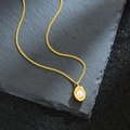 Elegant gold peanut pendant necklace with textured metal and white pearl charm - Gold