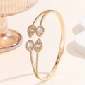 Detailed view of a gold double-layer open bangle set with teardrop and oval cubic zirconia - Gold Open Cuff Bangle