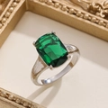 Macro shot of emerald cut green gemstone ring with textured silver band details - Silver Emerald Green