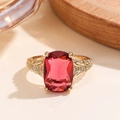 Macro shot of rectangular red ruby ring with gold leaf-patterned band and diamonds - Gold Magenta