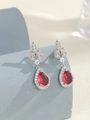 Dettaglio di orecchini a goccia in argento con pietre rosse e piccoli zirconi bianchi - Stile Fiore a Goccia / Argento Fucsia