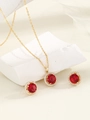 Detail of halo jewelry set with red stones and gold plating on white stone display - Gold-Red Zirconia