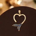 Detailed close-up of a gold hollow heart pendant with a blue fish tail crystal design - Gold Fishtail