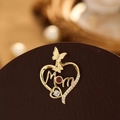 Vue détaillée du pendentif cœur Mom en or avec une pierre rouge et de petits diamants - Lettre Or