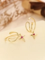 Dettaglio di ear cuff dorato con stella in zircone rosso e linee metalliche lisce - Stile Linea Stella a Quattro Punte (TE-09191-01) / Oro