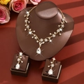 Macro shot of gold floral necklace set with sparkling teardrop crystals on neck display - Vine Flower Style (1729) / Gold