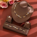 Close-up of golden vine necklace and blue flower jewelry set on leather display - Floral Vine Style (1737) / Blue