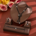 Detailed close-up of black rhinestone bridal jewelry set on premium brown leather display - Black