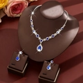 Macro shot of silver bridal necklace and drop earrings with deep blue waterdrop crystals - Two-Piece Set / Blue
