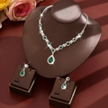 Macro detail of bridal jewelry set with pear-cut emerald gemstones and silver zircon inlay - Two-Piece Set / Green