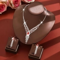 Elegant silver jewelry set with red teardrop rhinestones on dark display stand - Two-Piece Set / Red