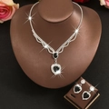 Elegant silver heart necklace and earring set with black gemstones on a display model - Set / Black