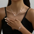 Detail view of rose gold bridal jewelry set with sparkling rhinestones on elegant model - Rhinestone Necklace Bracelet Ring Earrings 4-Piece Set (425747) / Rose Gold