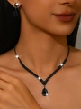 Macro shot of V-shaped rhinestone necklace with matching water-drop earrings for weddings - Gun Black Necklace Earrings