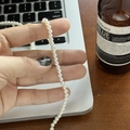 Nahaufnahme einer kleinen 3-4mm weißen Perlenkette, die von einer Hand gehalten wird - 4mm / Weiß (4MM)