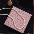 Collier de perles rondes blanches élégant sur un plateau décoratif rose texturé - Blanc (Petit Style)