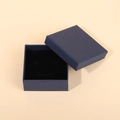 Macro shot of navy blue jewelry gift box featuring a ribbon bow and black velvet interior - Gift Box / Deep Sea Blue