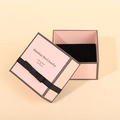 Close-up of pink square drawer jewelry box with black ribbon bow and velvet padding - Sakura Pink
