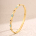 Dettaglio del bracciale a cerniera dorato con cuore blu e pietre di zircone scintillanti - Oro Verde