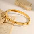 Elegant gold-plated stainless steel bangle featuring five sparkling heart-shaped rhinestones - Gold Heart Bangle