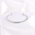Brazalete rígido plateado minimalista con diseño trenzado sobre seda blanca - Plateado Abierto (Espiral)