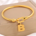 Gouden gedraaide kabelarmband met een hoefijzersluiting en letter B hanger - Gouden Armband Letter B