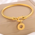 Gouden gedraaide roestvrijstalen armband met ronde bedel op een luxe sieradendoosje - Gouden Armband Letter O