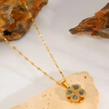 Macro detail of rotating four-leaf clover pendant with blue heart crystals and gold plating - Blue
