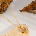 Detailed macro view of a 18k gold-plated clover necklace with sparkling zircon stones - White