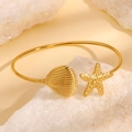 Gouden roestvrijstalen armband met zeester en schelp bedeltjes in een strandthema - Gouden schelp en zeester armband