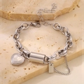 Détail d'un bracelet chaîne en acier inoxydable argenté avec breloque cœur et pompons - Bracelet / Cœur Argent avec Chaîne